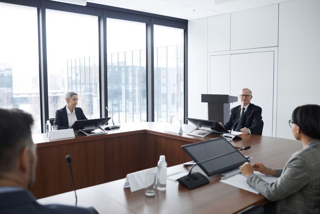 A board in session around the table, papers and agenda in front of them
