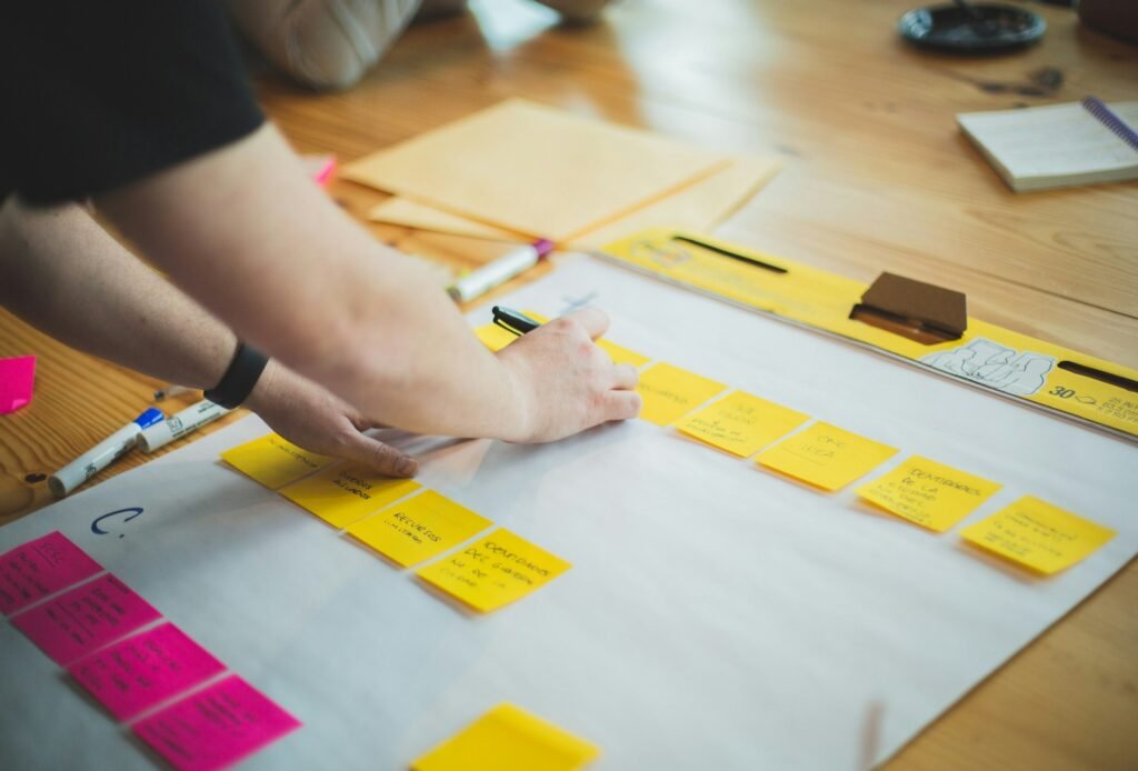 Hands arranging cards across a table during a commercial planning session