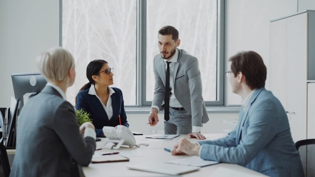 Colleagues reviewing reports and contract terms around a meeting table